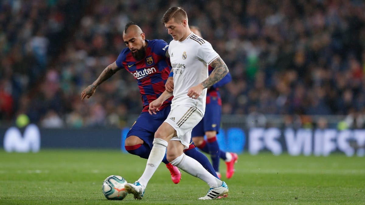 Toni Kroos of Real Madrid shields the ball from Barcelona's Arturo Vidal