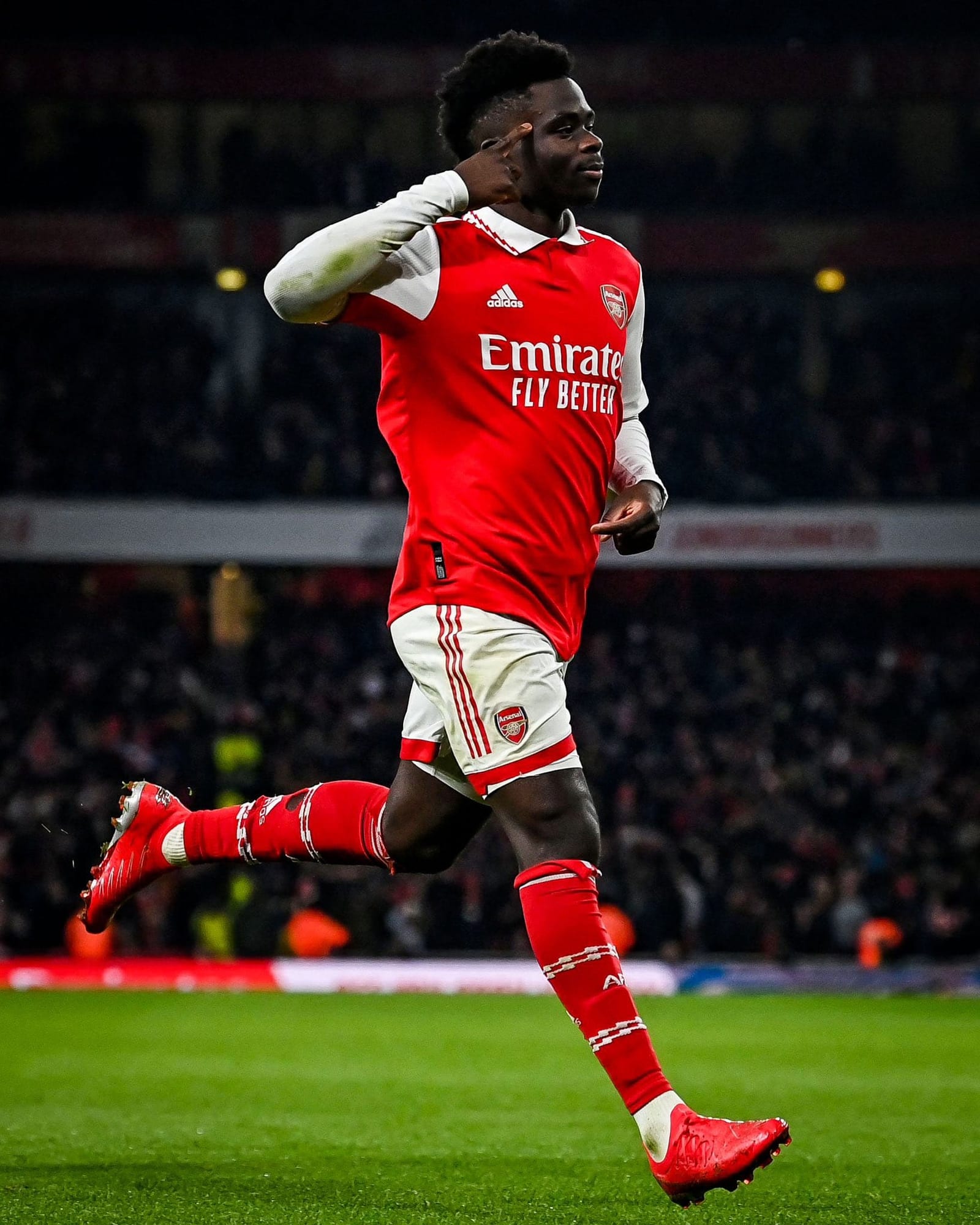 Bukayo Saka runs and salutes after scoring for Arsenal