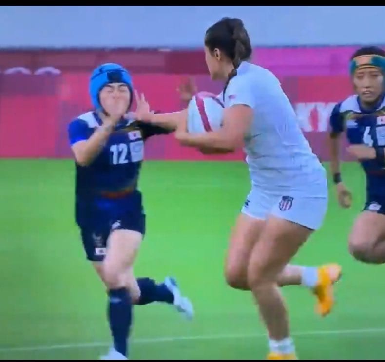 Broadcast frame, rugby sevens at the Tokyo Olympics: a United States player hands off a Japan defender